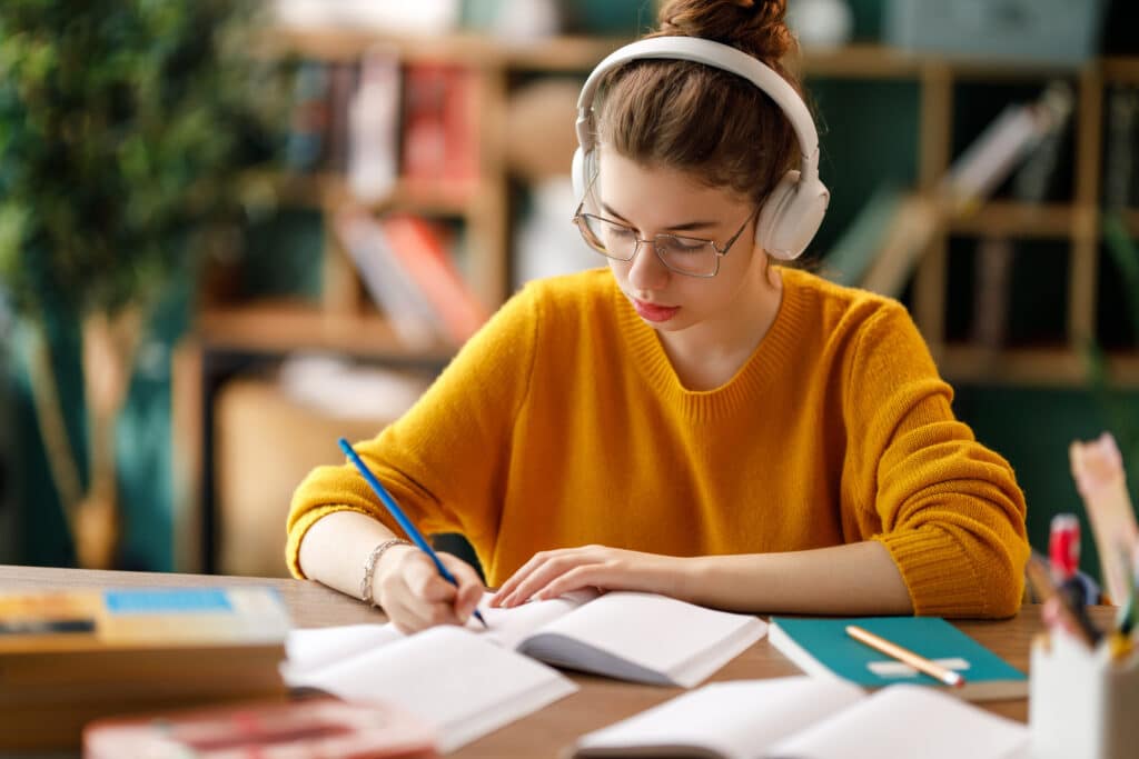 Adolescente entrain de travailler dans une biblioth&egrave;que